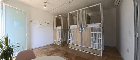 Una habitación con techo, puerta y mesa blancos, además de una planta en maceta.