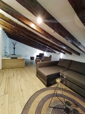 Relax in a spacious living area with a high ceiling, featuring a sofa, coffee table, and cozy seating area.