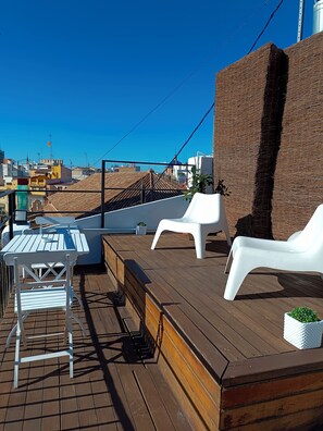 Relax on the outdoor deck with a casual dining area, complete with a table and chairs.