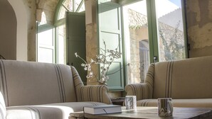 A cozy seating area with striped sofas, a wooden coffee table, a book, and a mug. - Fontes Episcopi (Aragona)