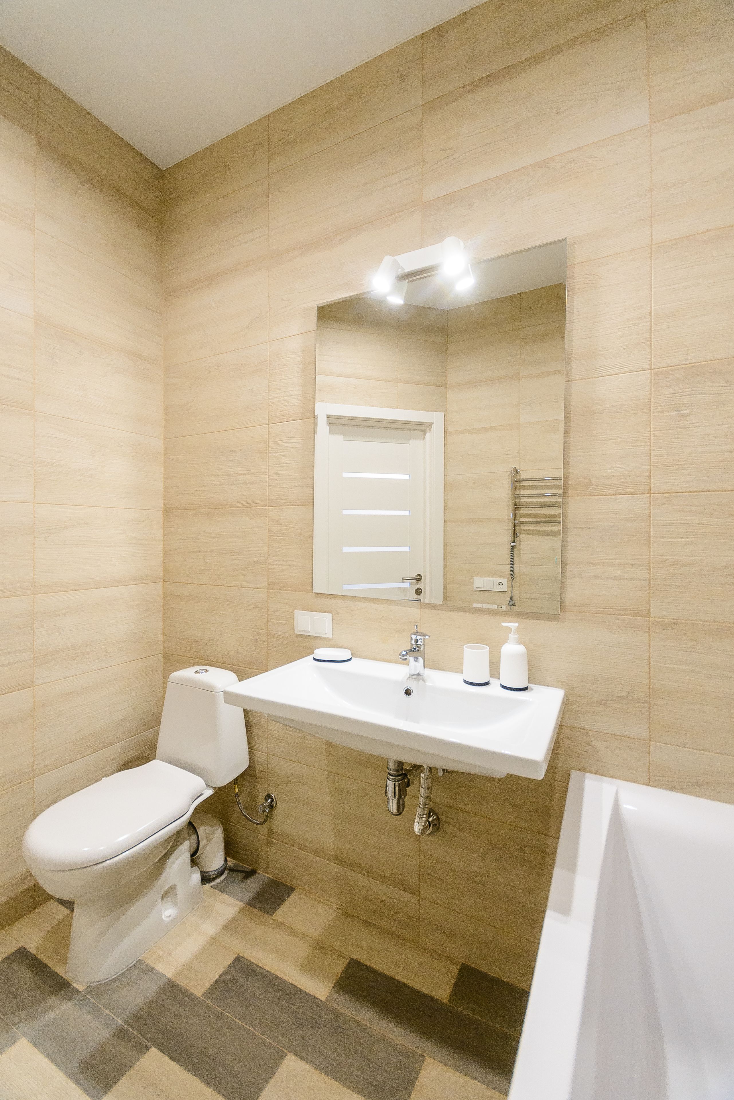 Une salle de bain moderne équipée de toilettes, d’un lavabo et d’une baignoire.