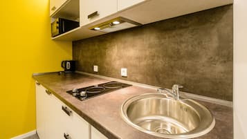 Departamento de diseñador, 1 habitación, torre | Cocina privada | Refrigerador, microondas, parrilla de estufa y cafetera y tetera
