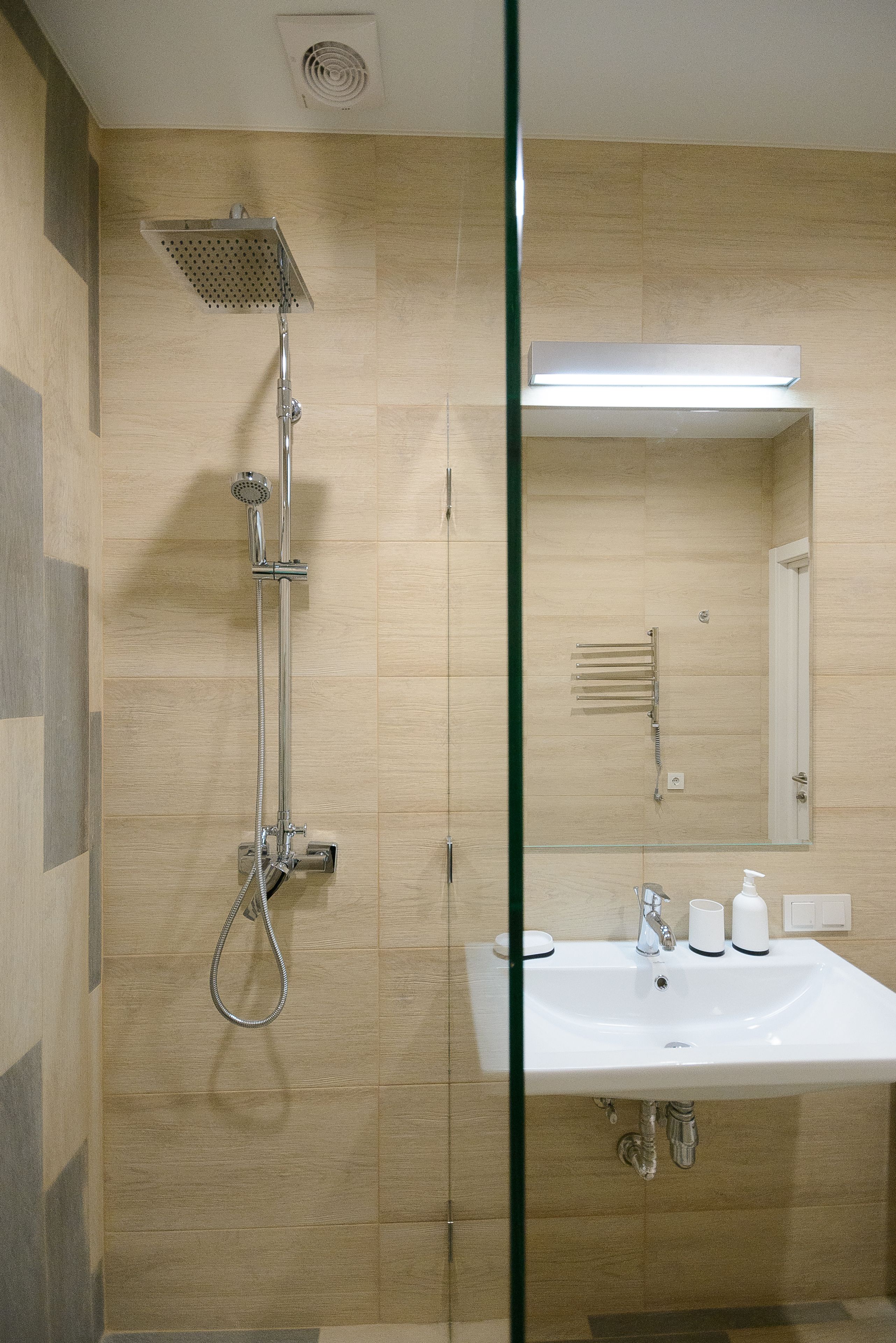 Un baño moderno con ducha, lavabo y espejo.