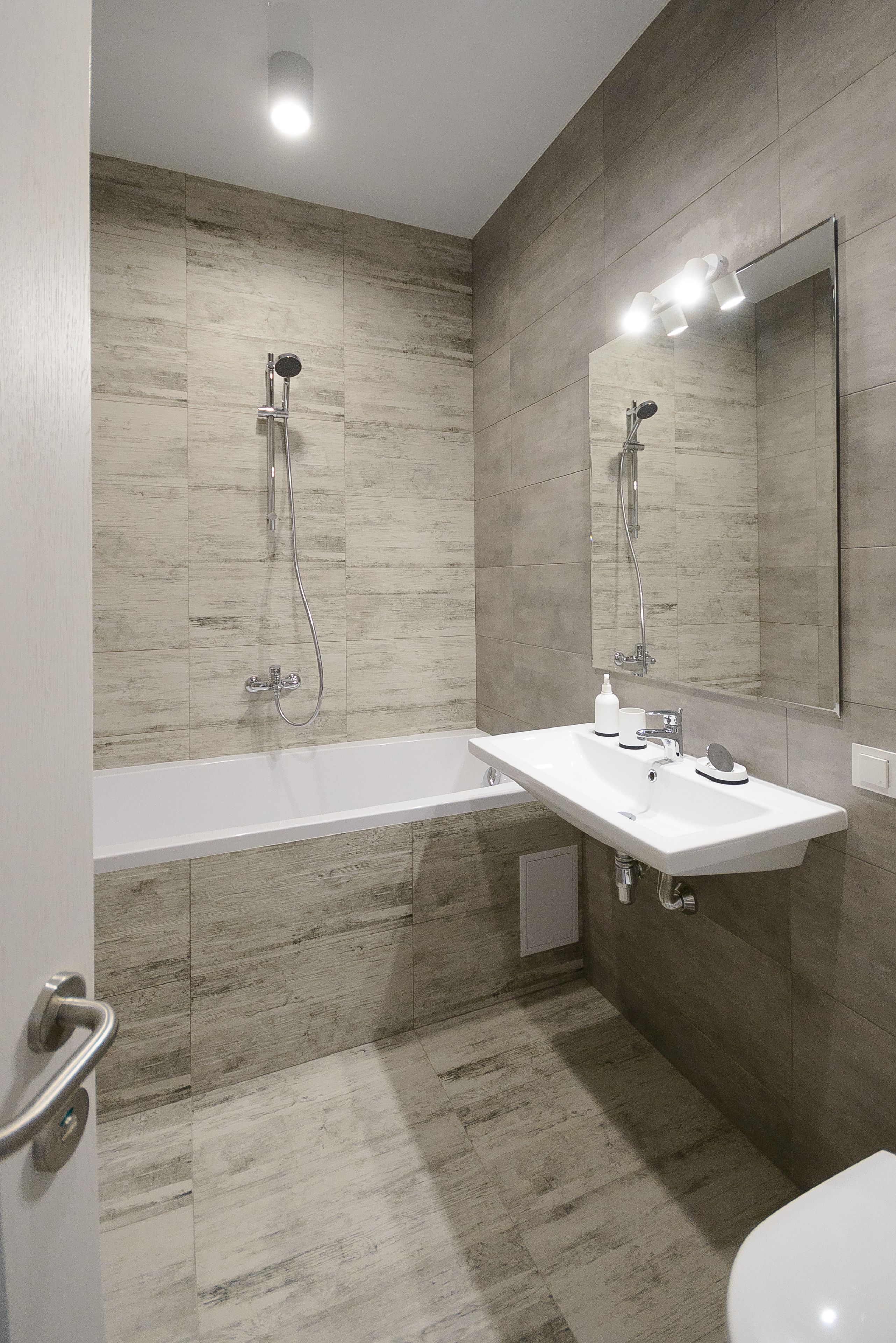 Ein modernes Badezimmer mit Badewanne, Waschbecken und Toilette.