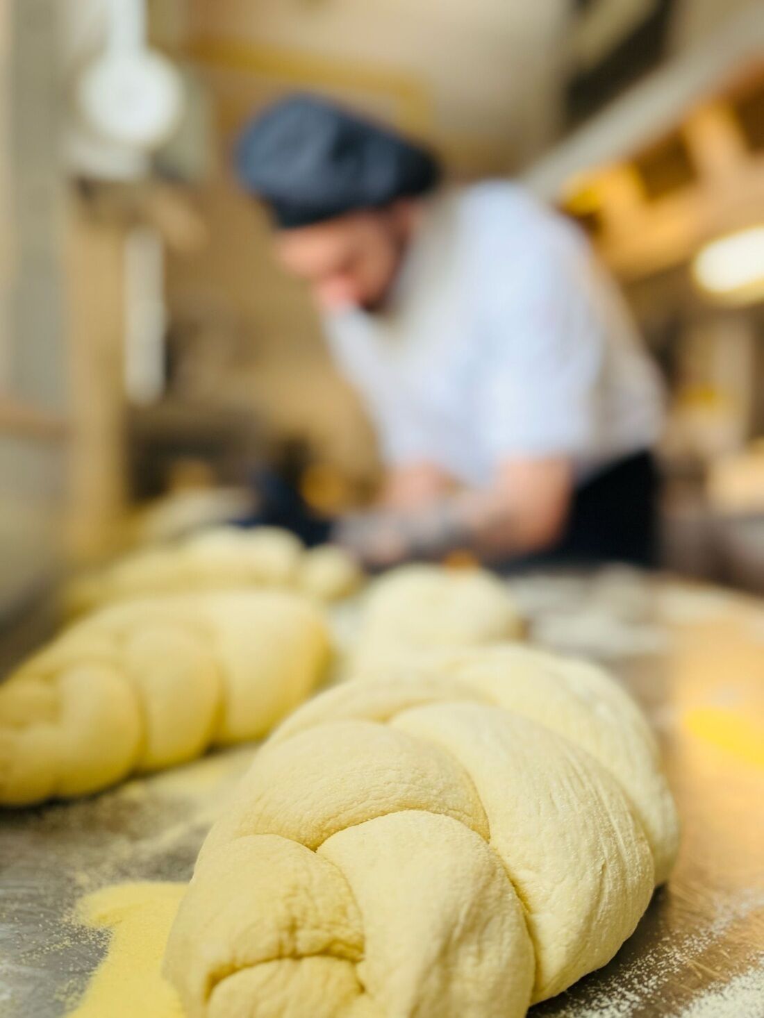 A dough preparation area with a person in the background.