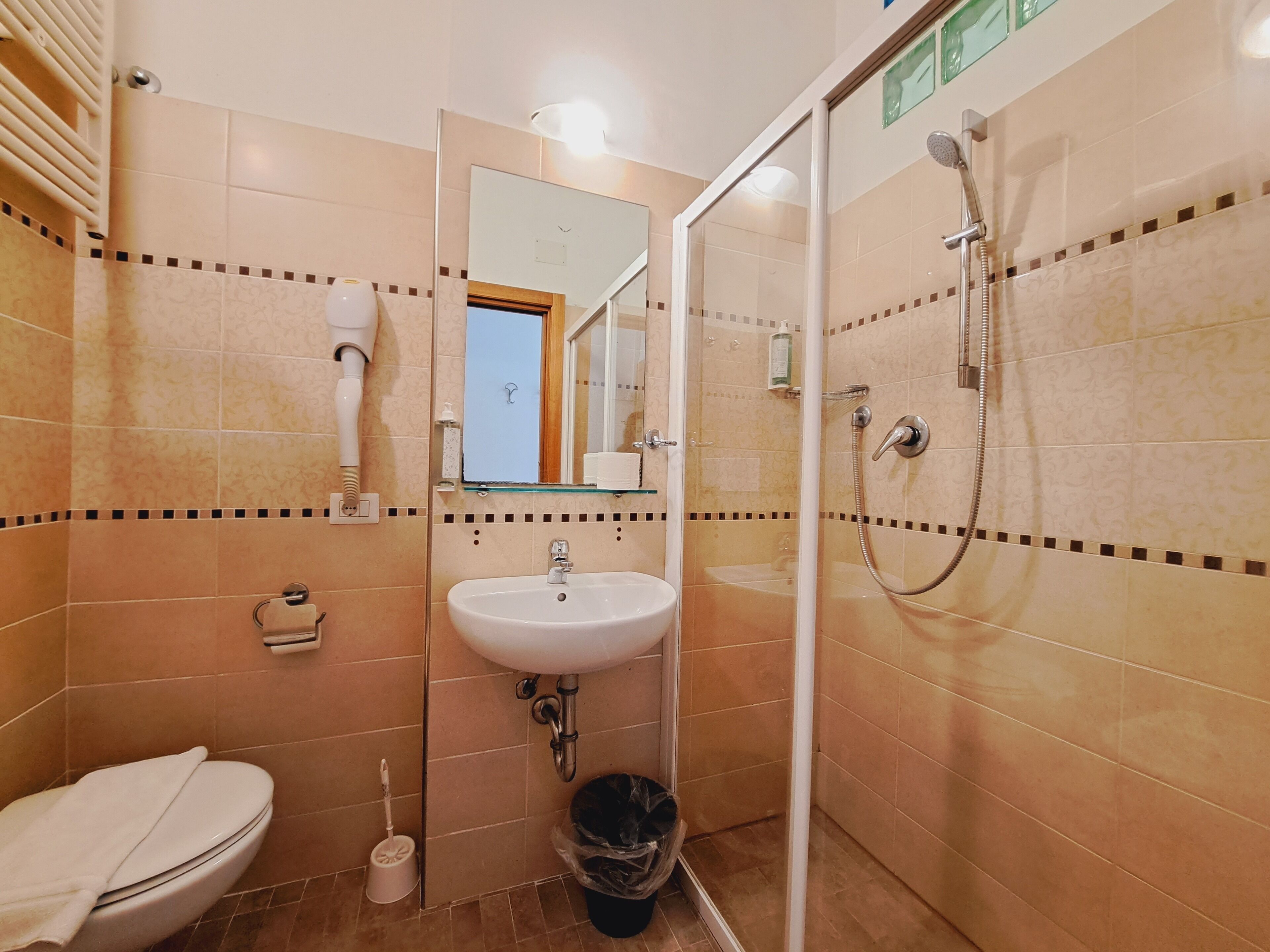 A bathroom with a toilet, sink, and shower.