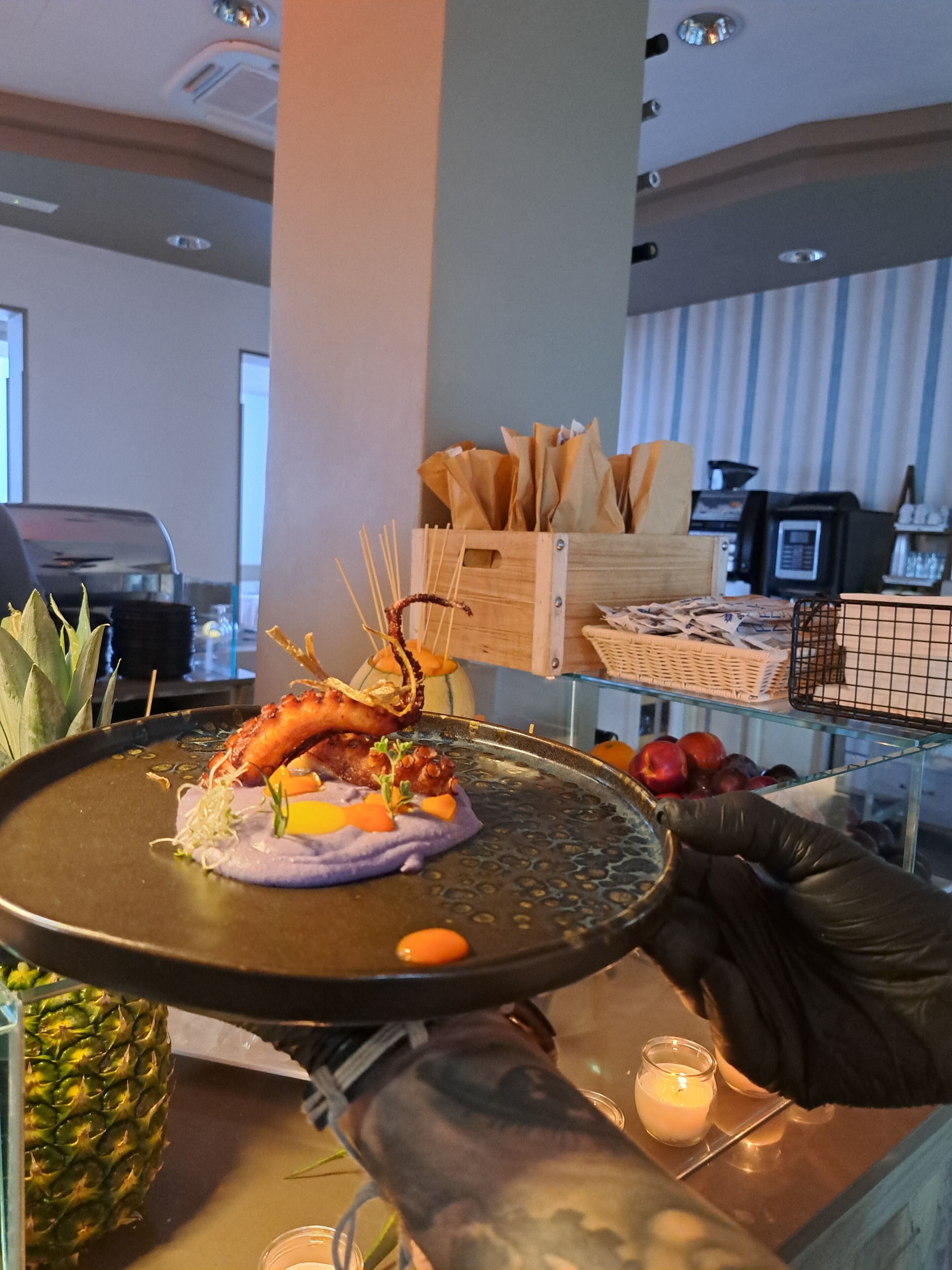 A dining table with a variety of dishes, including seafood and fruits, in a restaurant setting.