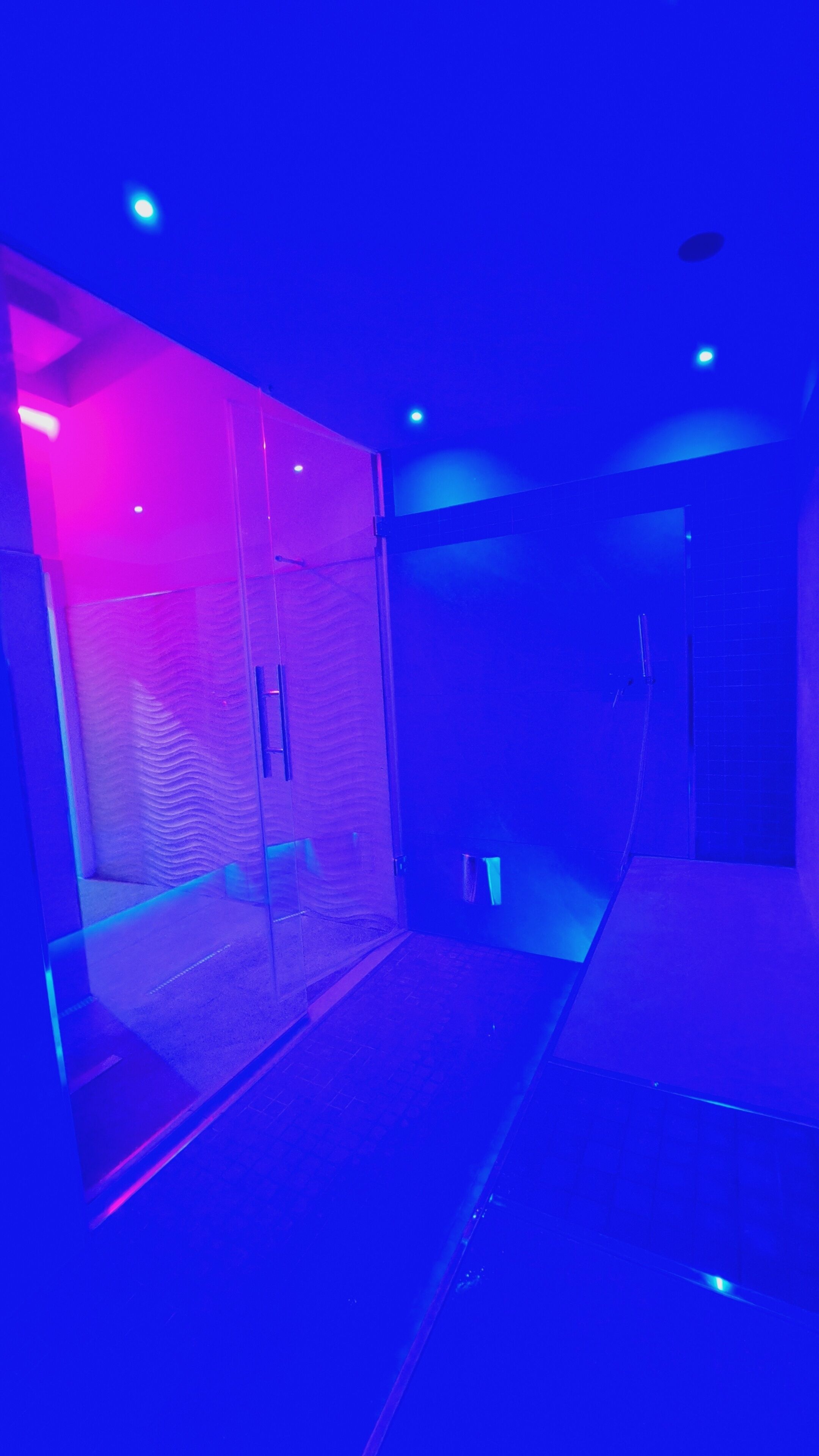 A room with a glass partition, a door, and a tiled floor.