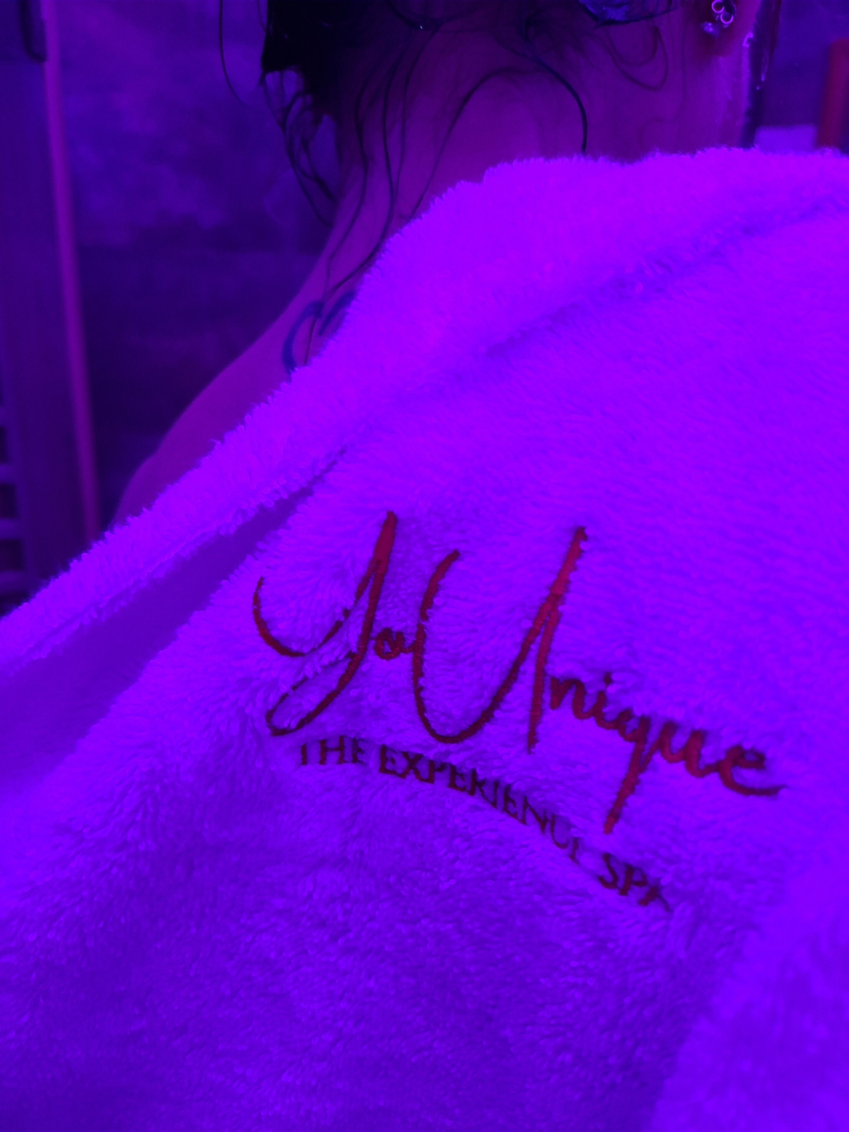 Een paarse handdoek met de tekst 'JoUnique THE EXPERIENCE SPA'.