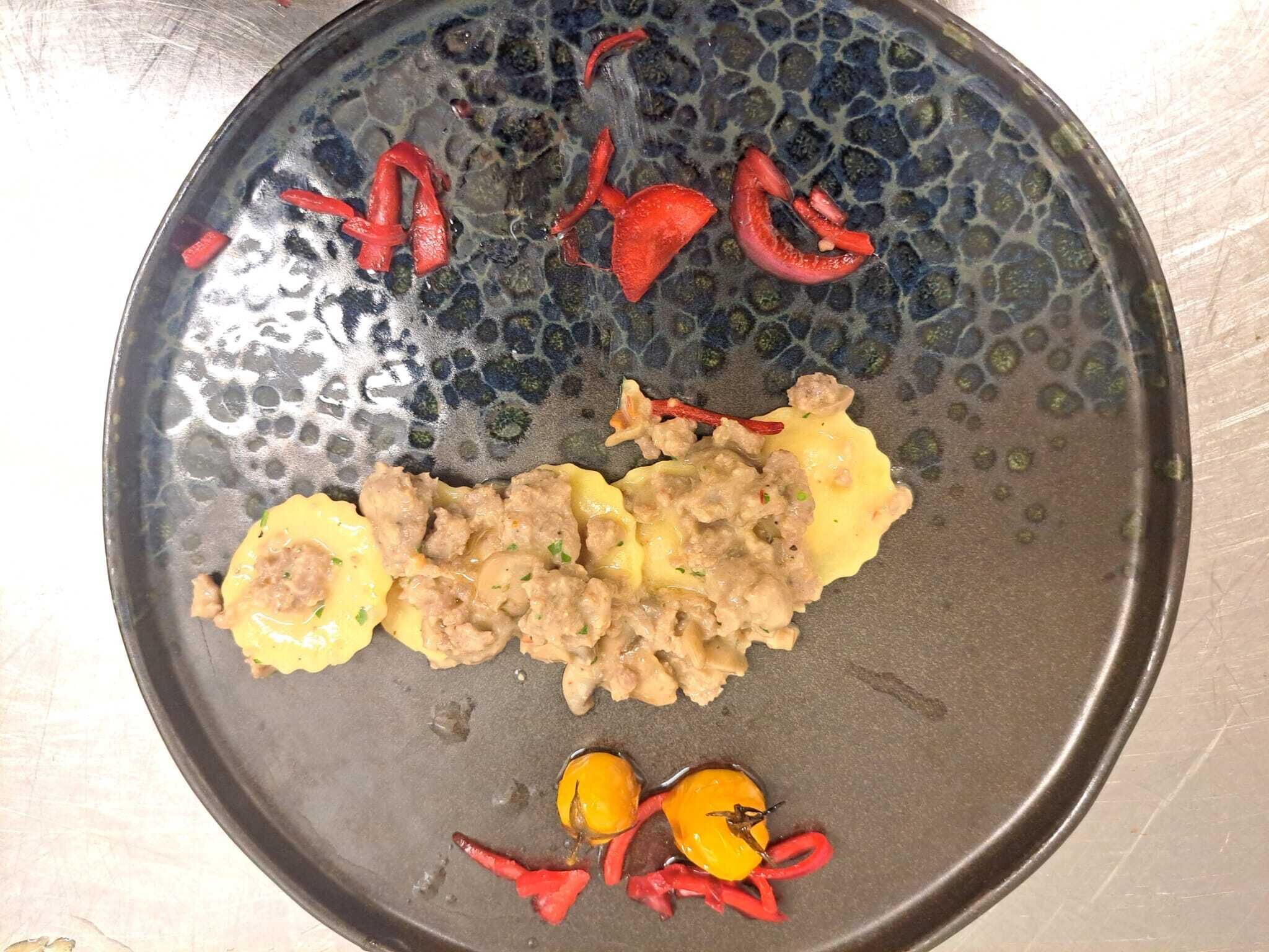 Une assiette contenant des aliments, dont ce qui semble être de la viande et des légumes, est posée sur une assiette à surface texturée.