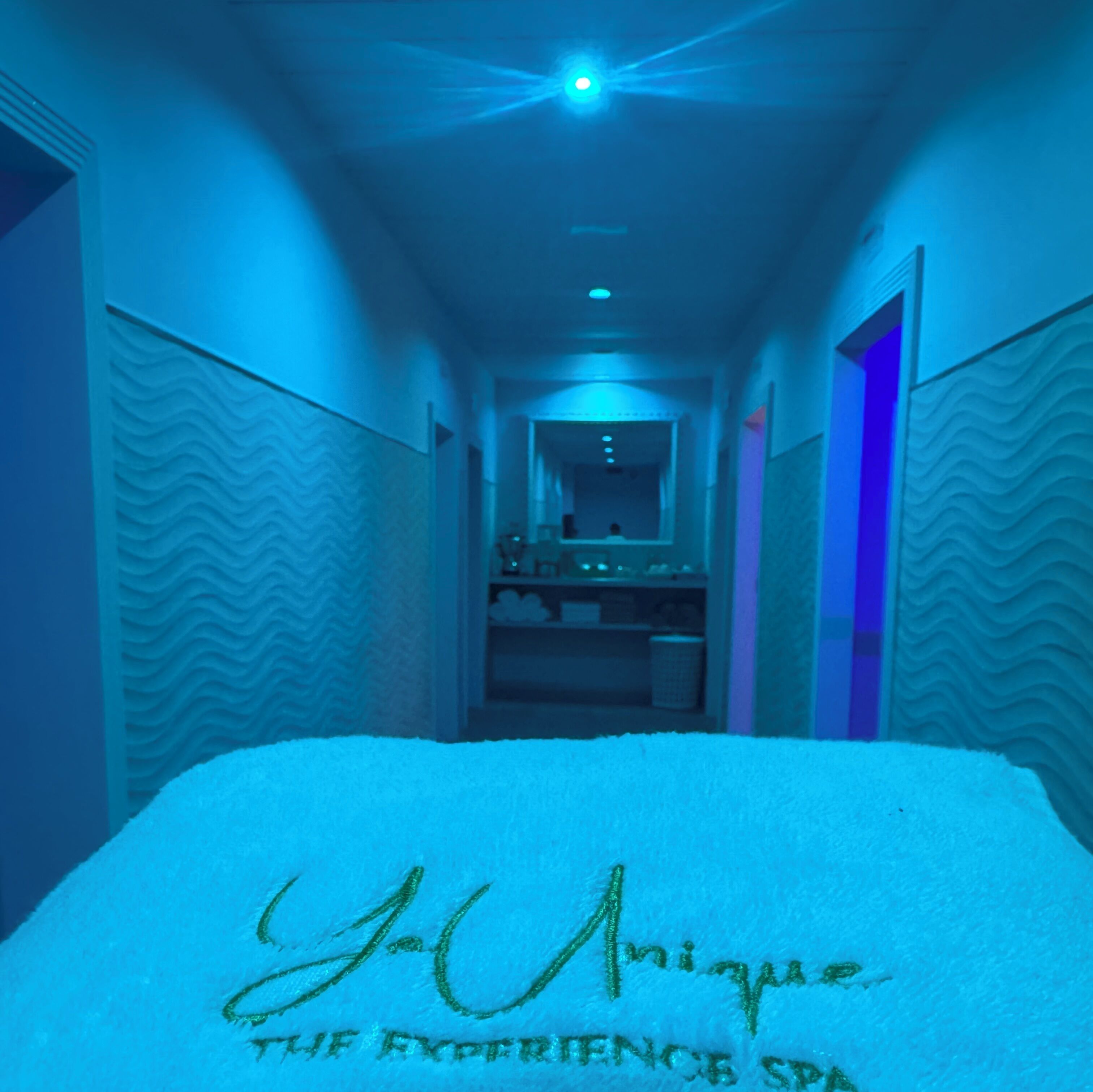 A hotel corridor with a bed covered in snow, a mirror, and a door on the right.