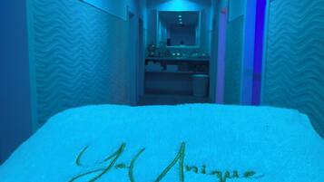 Un pasillo de hotel con una cama cubierta de nieve, un espejo y una puerta a la derecha.