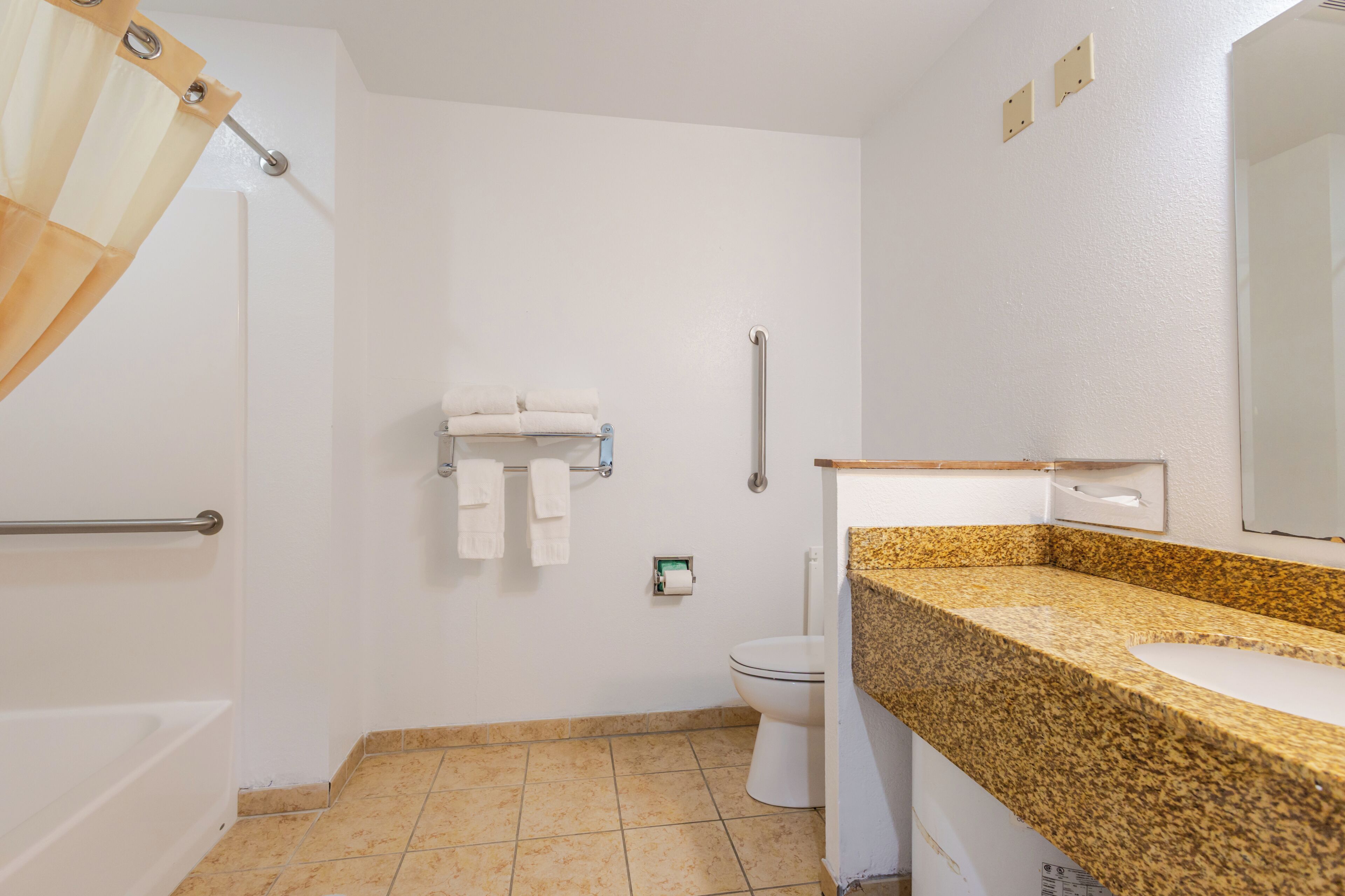 A bathroom with a shower, toilet, and sink.
