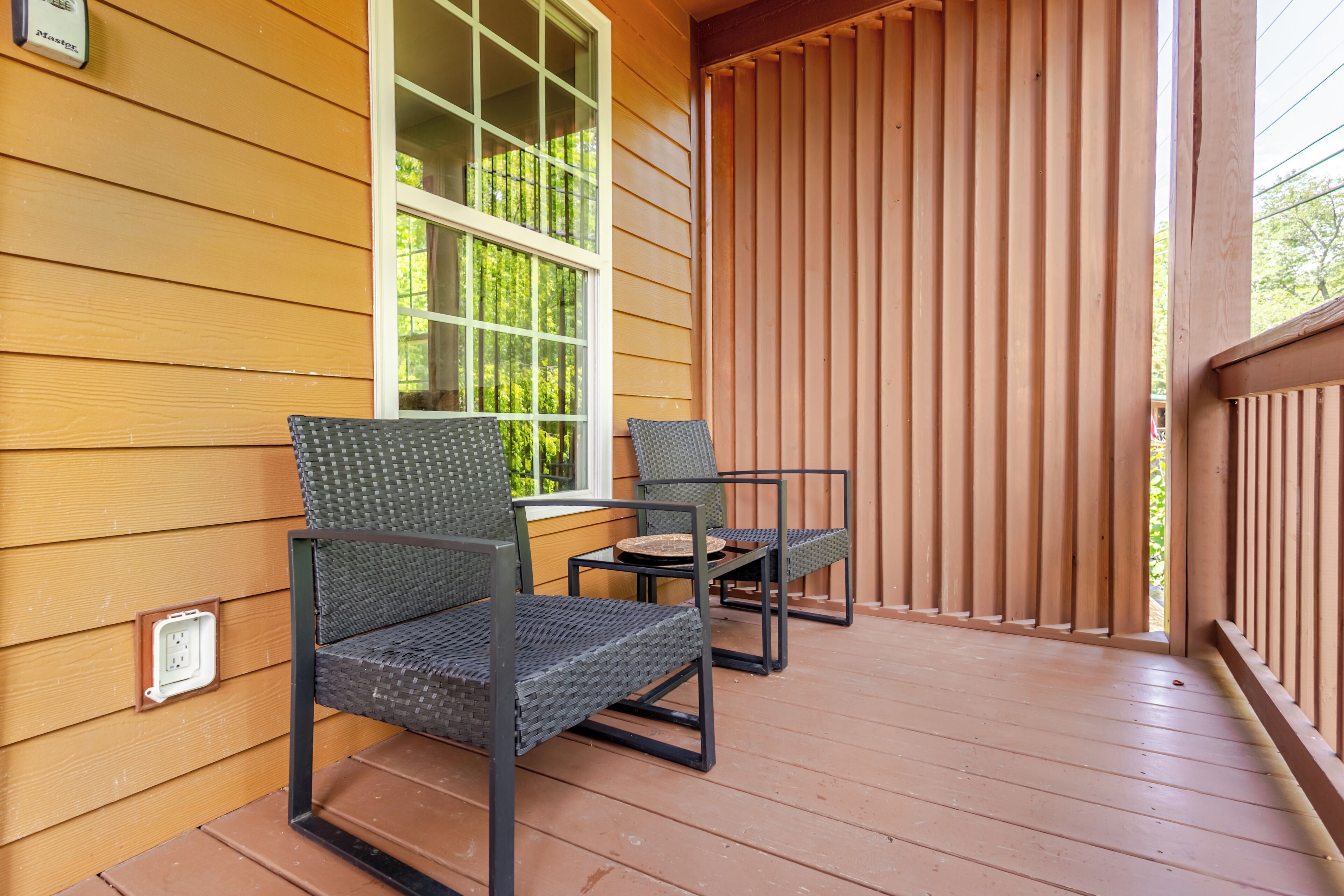A wooden deck with two chairs and a small table.
