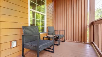 A wooden deck with two chairs and a small table.