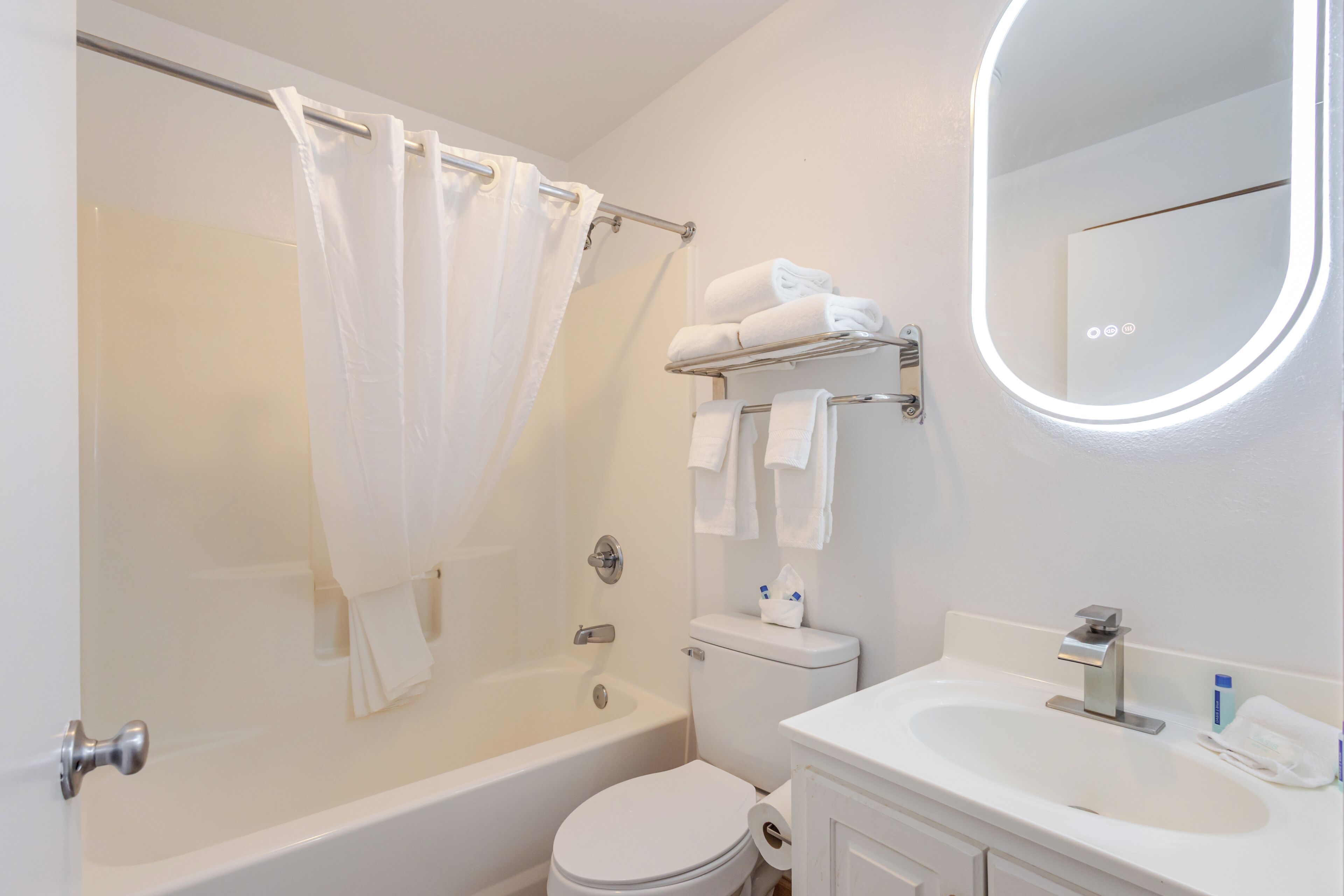 A modern bathroom with a bathtub, toilet, and sink.
