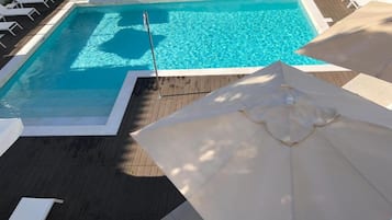 Een binnenzwembad, een buitenzwembad, ligstoelen bij het zwembad