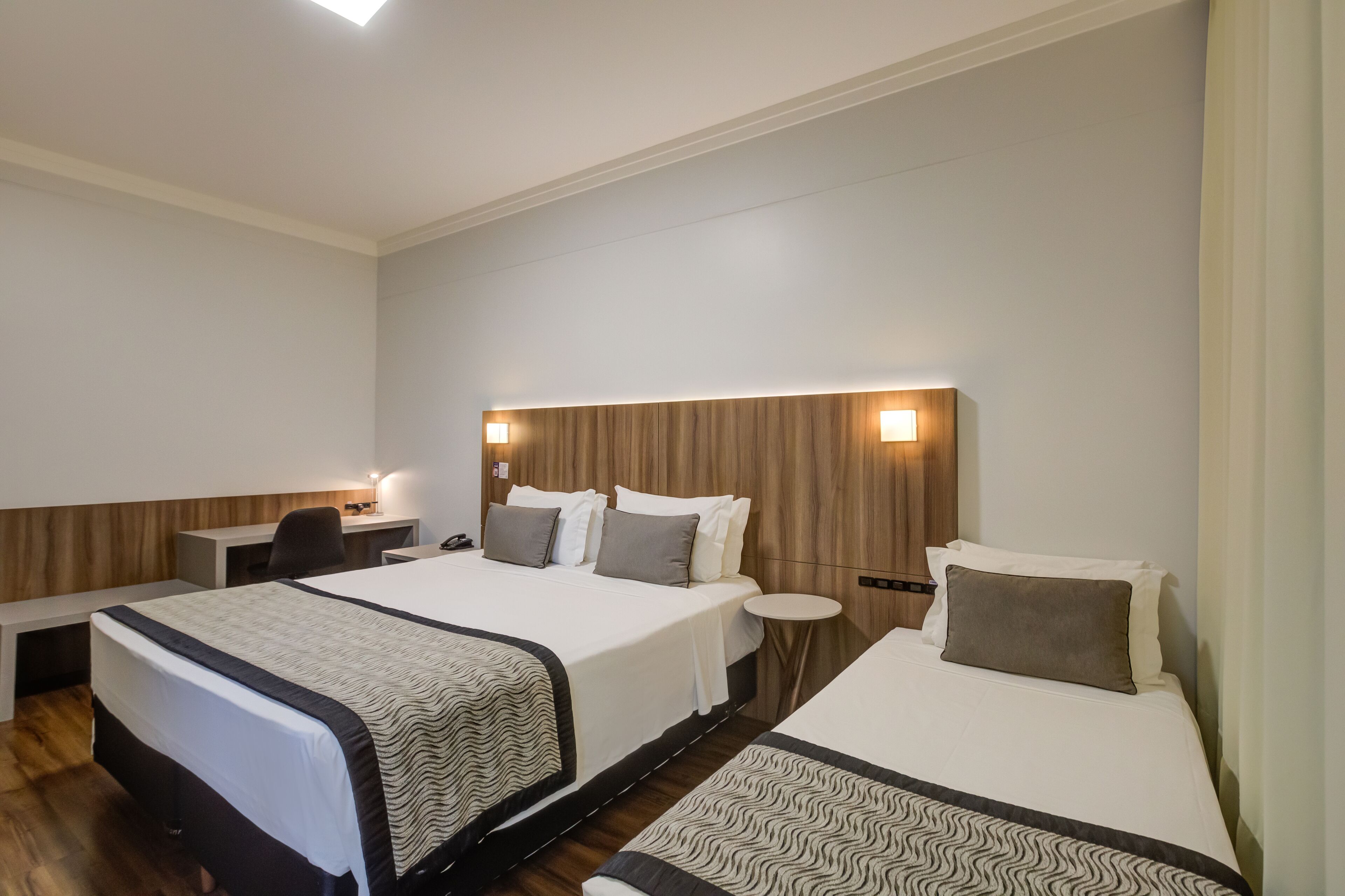Una habitación de hotel con dos camas, un escritorio y una silla.