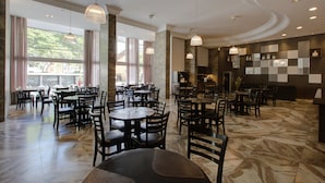 A spacious restaurant with multiple tables and chairs, large windows, and a marble floor. - SLAVIERO Blumenau (Blumenau)