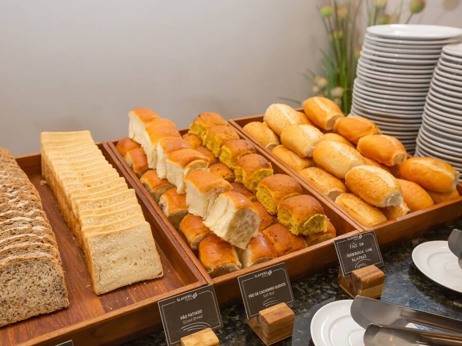 A variety of breads and pastries displayed in wooden trays.