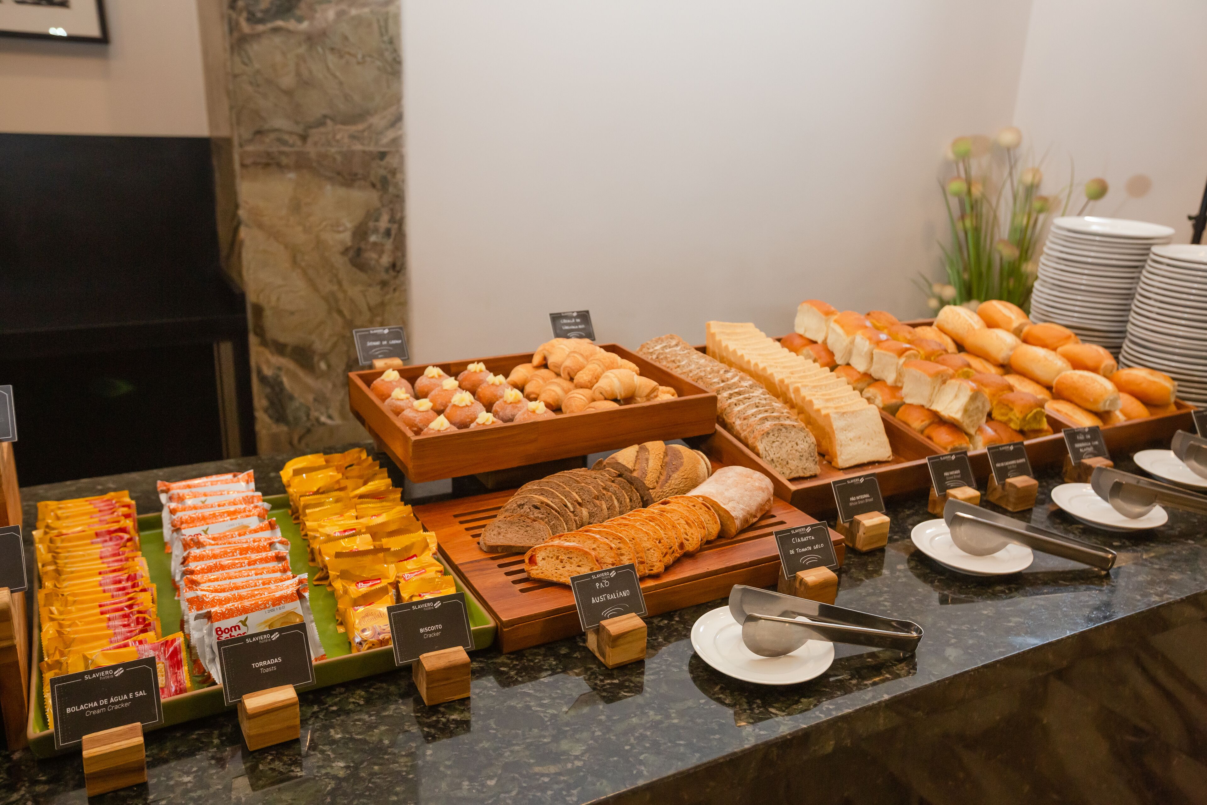 A buffet with various food items including bread, pastries, and snacks.