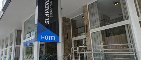A hotel entrance with a sign reading "Slaviere Essential Hotel."