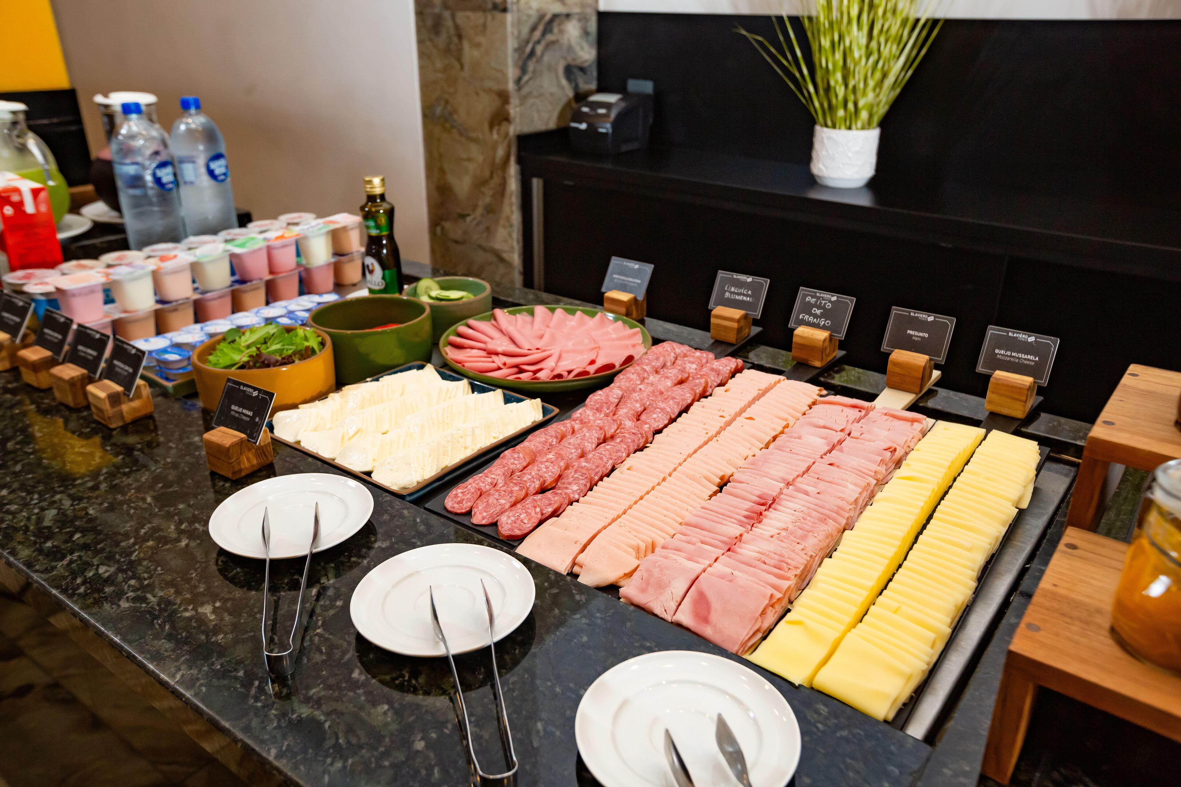 Ein Buffet mit verschiedenen Speisen, darunter Fleisch, Käse und Salate.