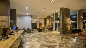 A spacious lobby with a marble floor, a reception desk, seating area, and a large window. - SLAVIERO Blumenau (Blumenau)