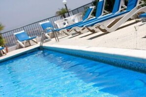 Piscine extérieure, parasols de plage, chaises longues