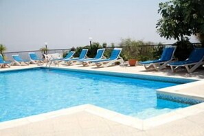 Piscine extérieure, parasols de plage, chaises longues