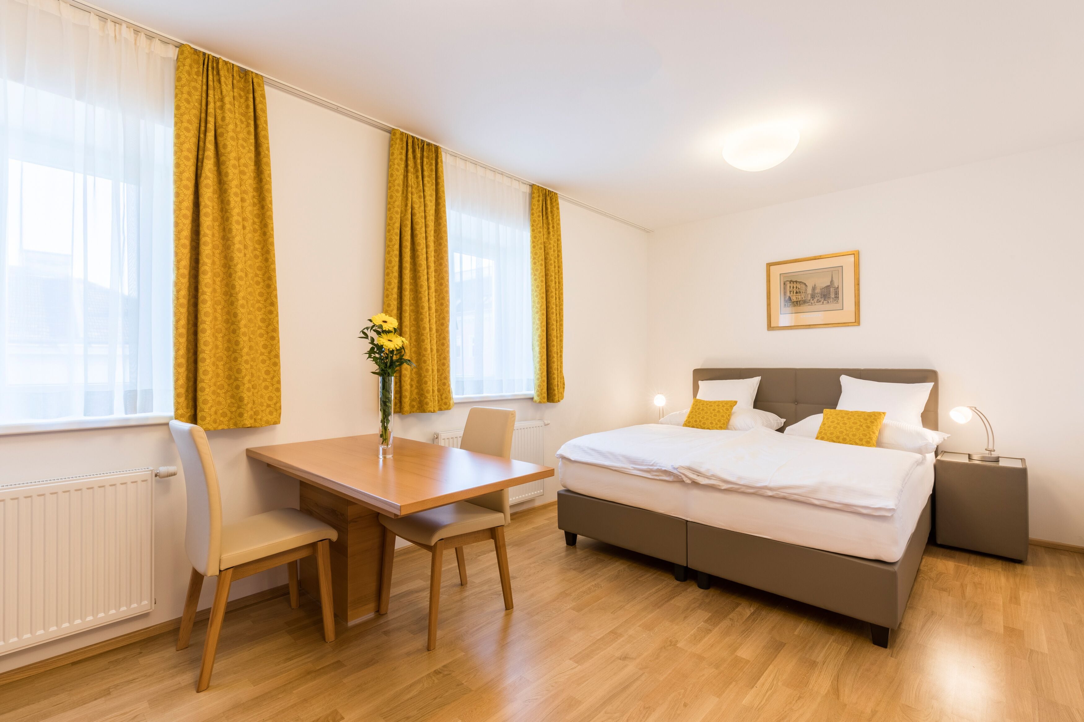 A bedroom with a bed, bedside table, lamp, and a window with curtains.