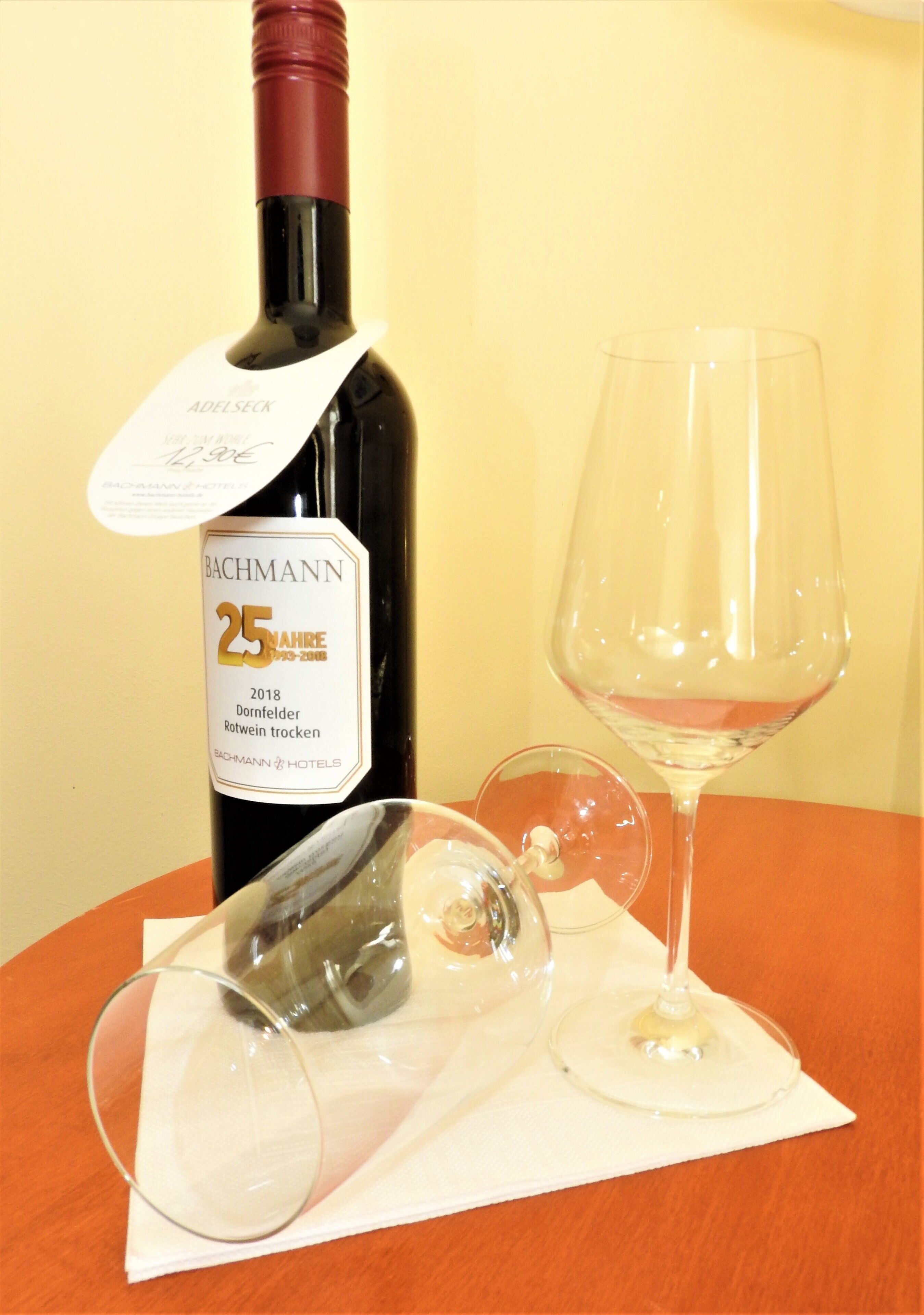 A bottle of wine and two glasses on a table.