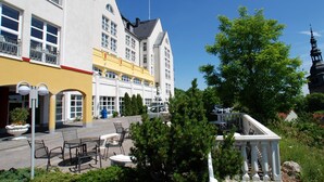 A hotel with a courtyard featuring outdoor seating, a fountain, and a statue.