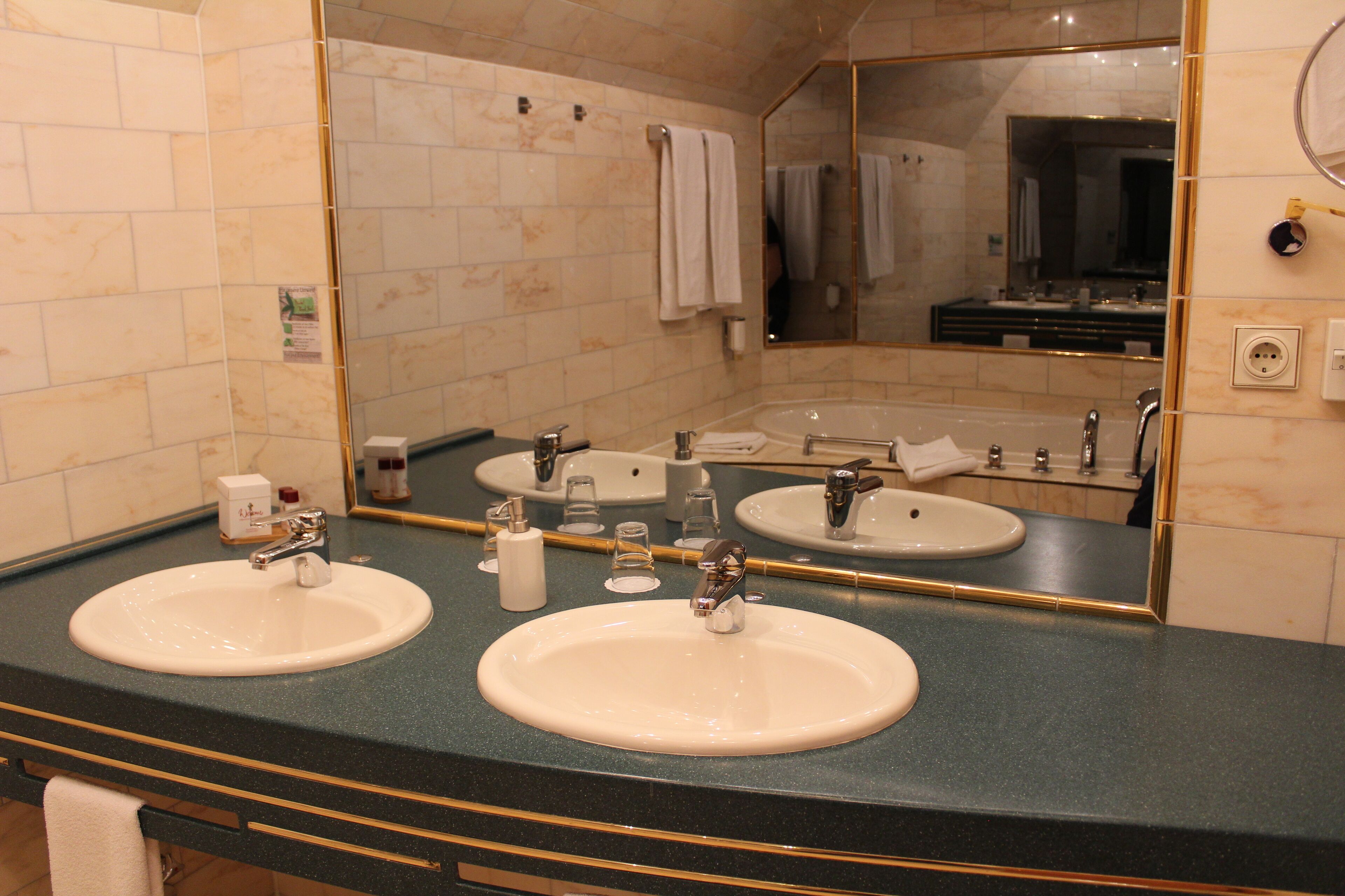 A bathroom with two sinks, a large mirror, and a towel rack.