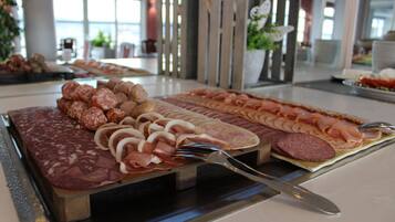 A buffet with various meats and cheeses.
