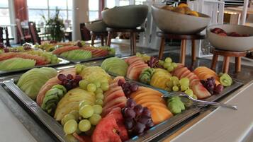 Un buffet proposant une variété de fruits et de légumes présentés sur des plateaux.