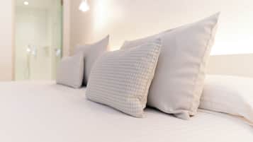 A neatly made bed with multiple pillows and a clean, minimalist design.