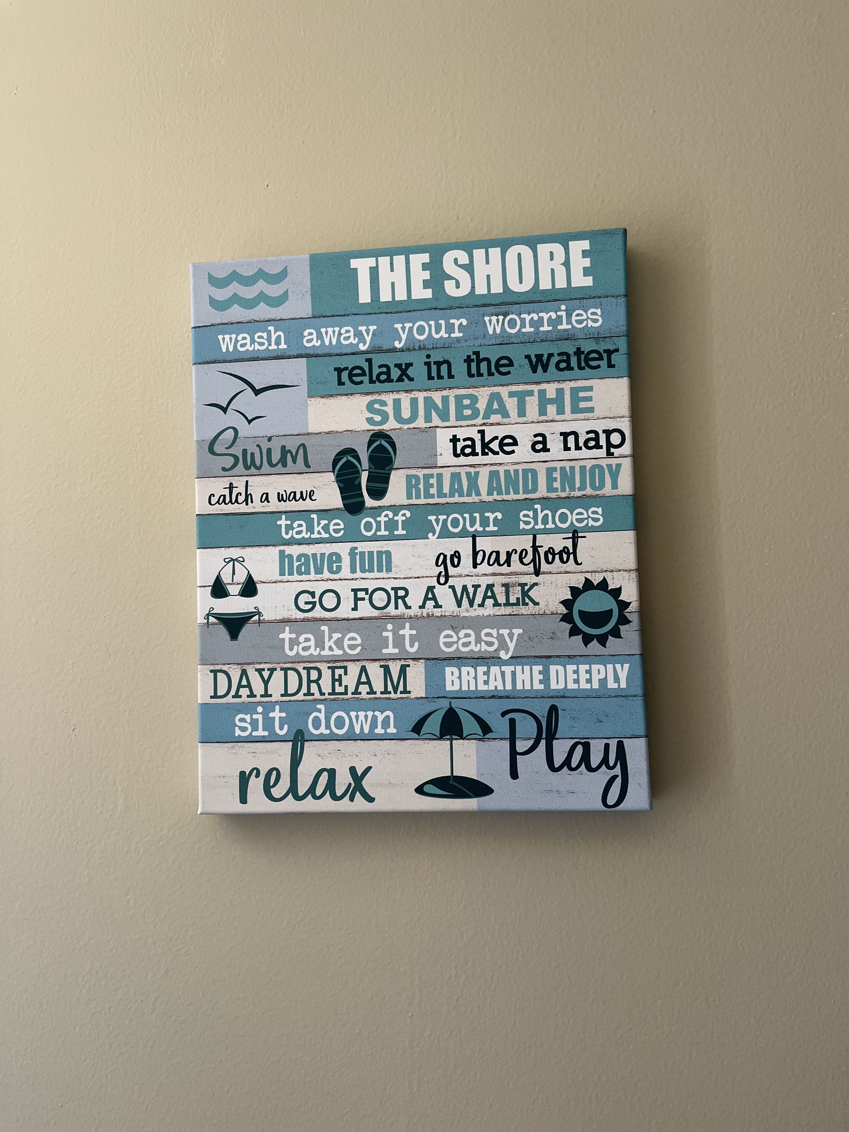 A wall decoration with motivational phrases related to relaxation and enjoyment.