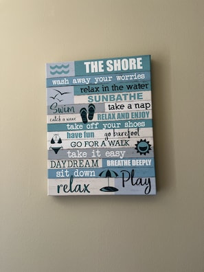 A wall decoration with motivational phrases related to relaxation and enjoyment.