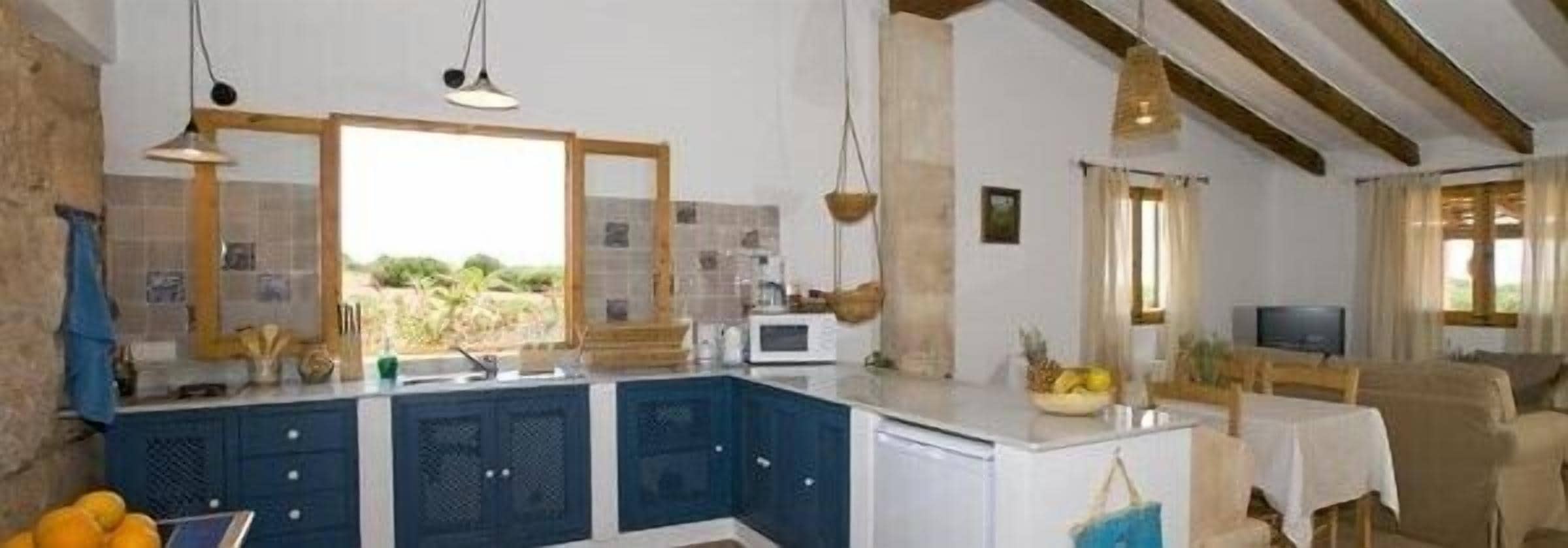 A kitchen with dark blue cabinets, a white countertop, and a hanging light fixture.