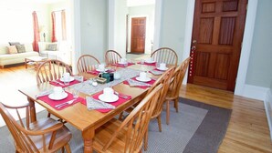 A dining area with a wooden table set for six, surrounded by wooden chairs. - 24 East Main Street B&B (Canton)
