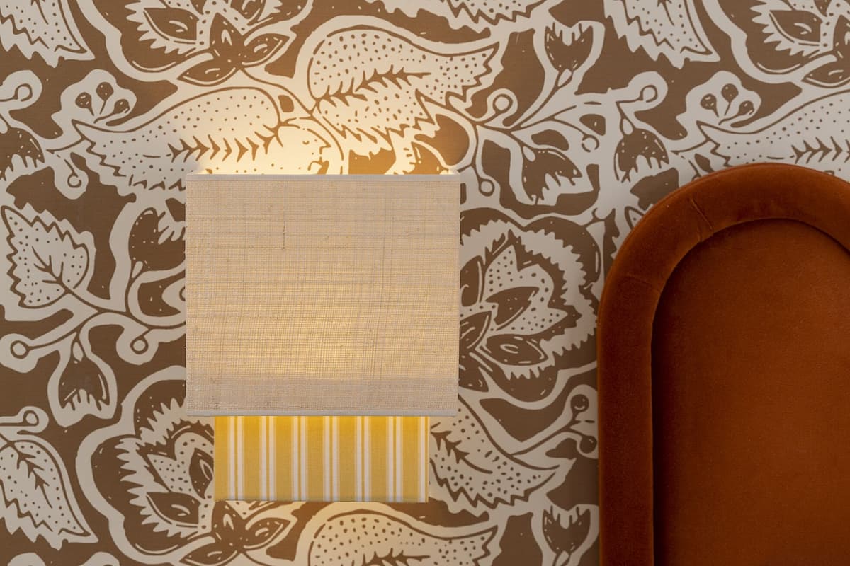 A patterned wallpaper with a central square area covered by a white cloth.
