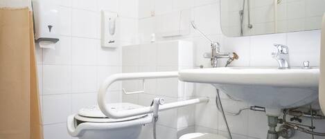 Un baño con inodoro blanco, lavamanos y ducha.