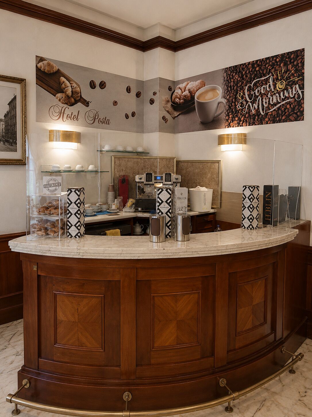 A hotel lobby with a central counter, coffee machines, a buffet area, and a wall with a 'Good Morning' sign.