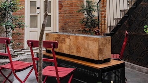A brick building with a balcony, a staircase, and outdoor seating. - Carlota Sustainable Design Hotel (Quito)