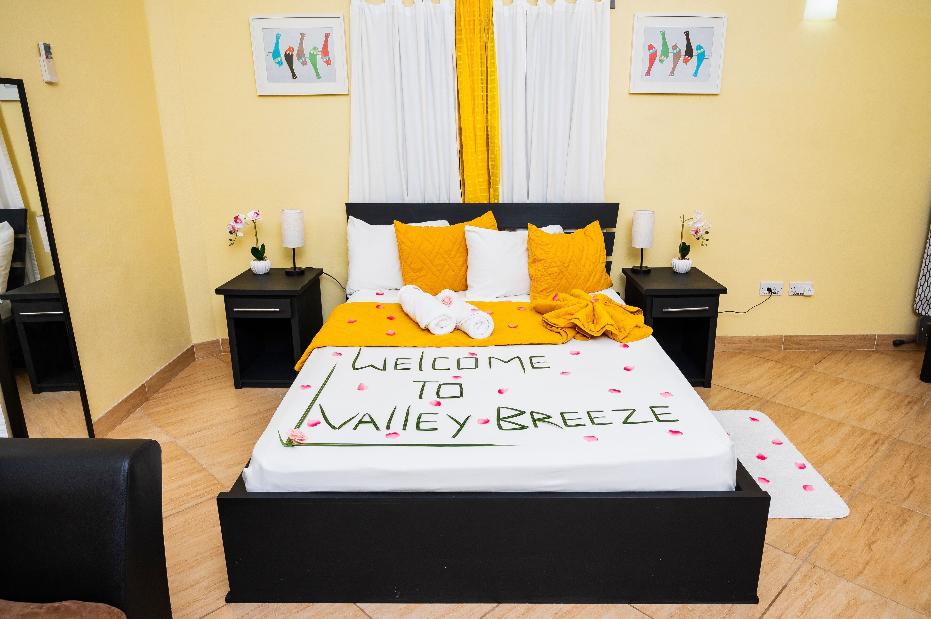 A neatly made bed with a welcome mat, pillows, and a blanket.
