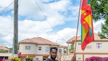 A man holding a flag in a residential area with houses and gardens.