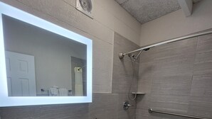 A modern bathroom with a pedestal sink, toilet, and walk-in shower. - Budget Inn Winter Haven (Winter Haven)
