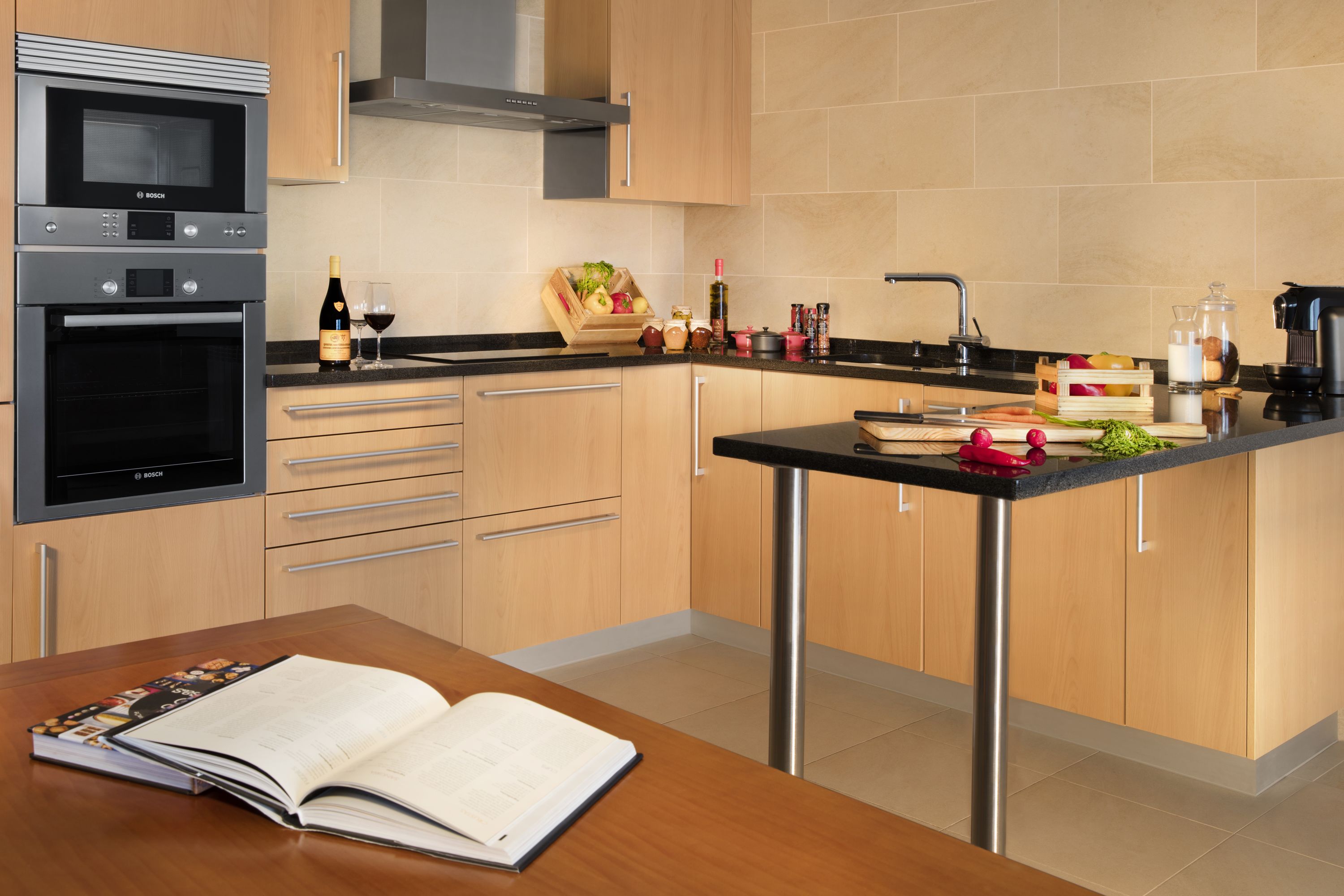 Una cocina moderna con electrodomésticos de acero inoxidable, armarios de madera y una isla central con fregadero.