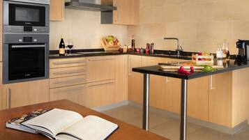 Una cocina moderna con electrodomésticos de acero inoxidable, armarios de madera y una isla central con fregadero.